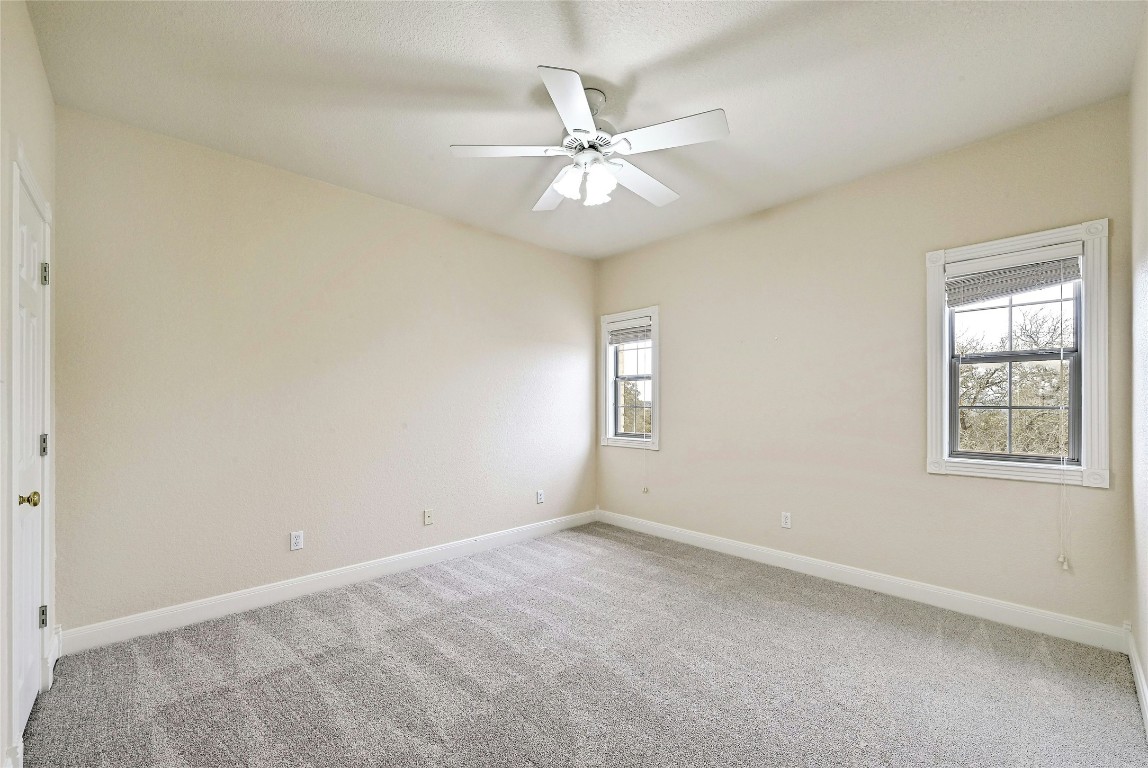 211 Summit Ridge Road Burnet, TX 78611 - Photo 20 of 35 an empty room with a window and a fan