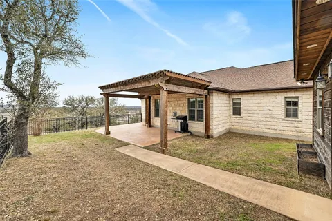 a view of a house with a yard and large tree