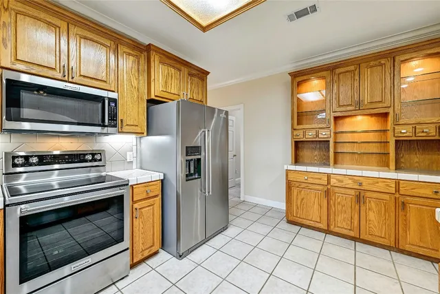 a kitchen with stainless steel appliances granite countertop a stove microwave and refrigerator