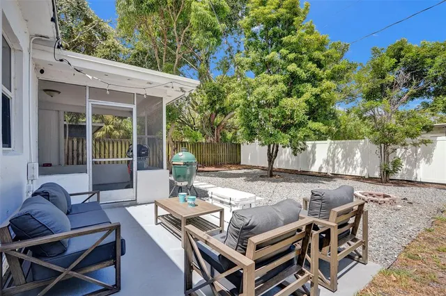 a view of a patio with table and chairs with wooden fence and plants