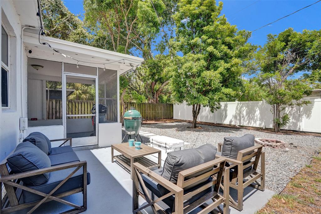 a view of a patio with table and chairs with wooden fence and plants