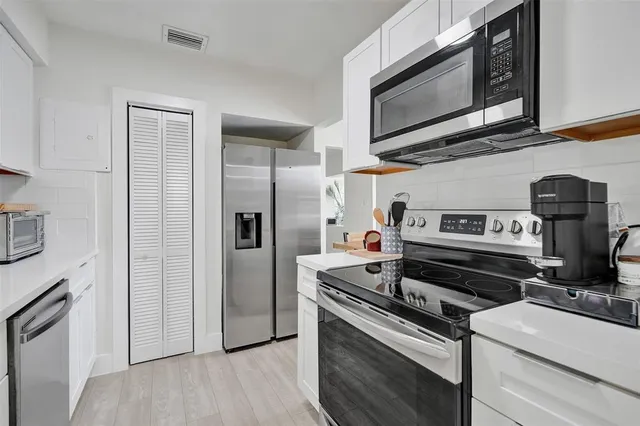 a kitchen with stainless steel appliances granite countertop a stove microwave and refrigerator