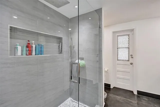 a bathroom with a shower and a glass door