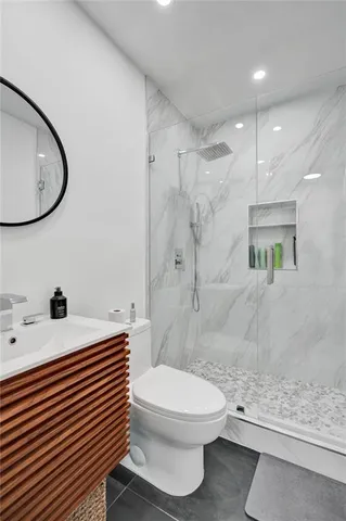 a bathroom with a sink a toilet and shower