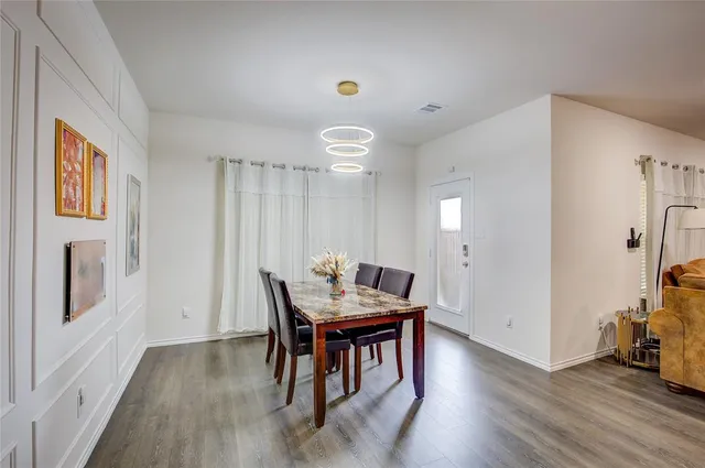 a living room with stainless steel appliances kitchen island granite countertop furniture and a wooden floor