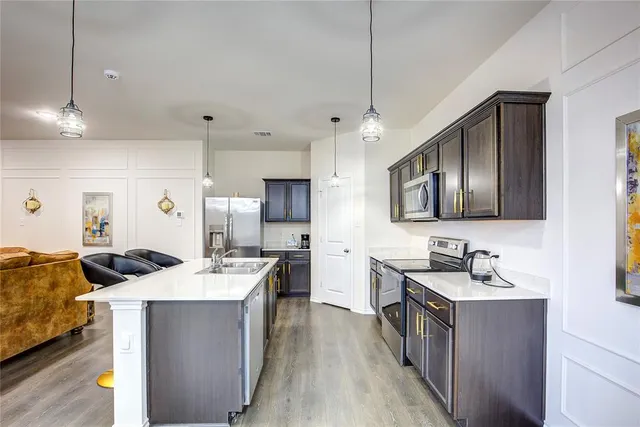 a kitchen with kitchen island a sink stove and refrigerator