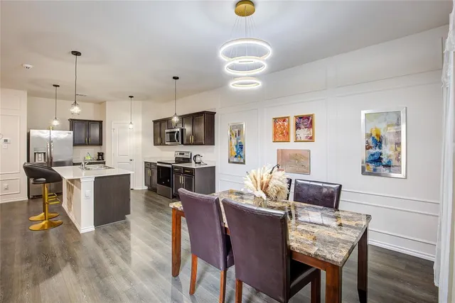 a kitchen with living room and chairs