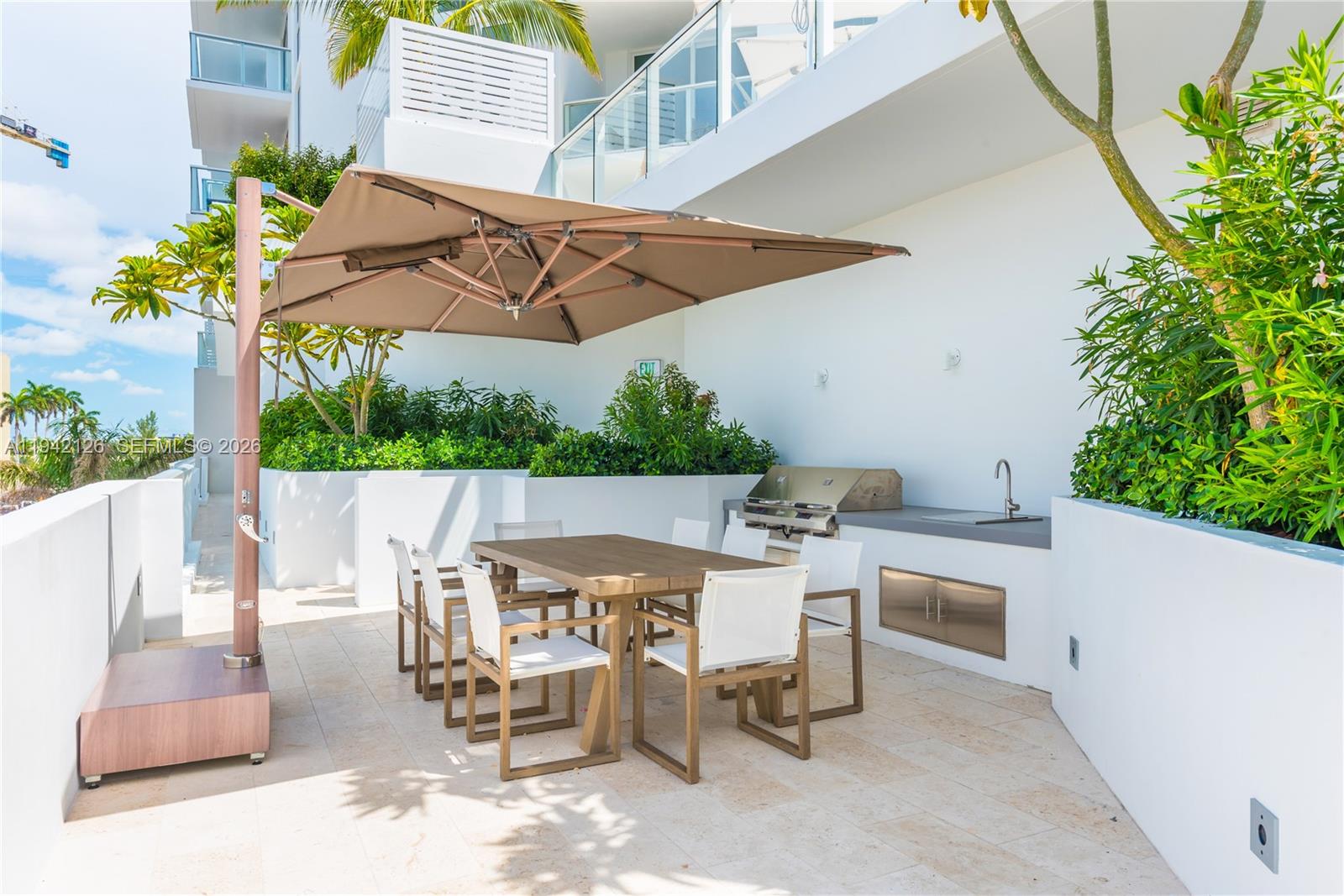 401 North Birch Road, Unit 701 Fort Lauderdale, FL 33304 - Photo 43 of 75 a view of a patio with table and chairs under an umbrella