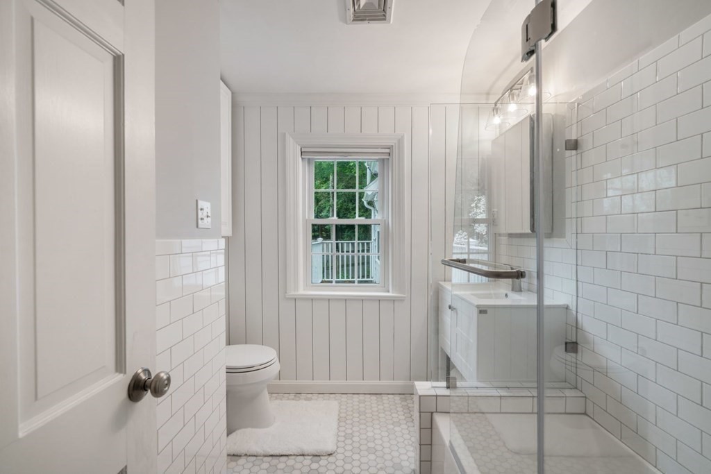 15 Woodridge Road Wellesley, MA 02482 - Photo 26 of 36 a bathroom with a granite countertop sink a toilet and shower