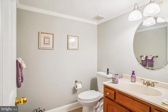 a bathroom with a sink vanity mirror and toilet