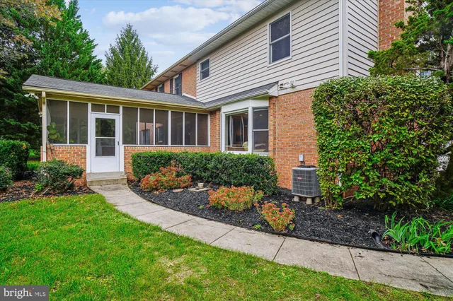 a front view of a house with a yard and potted plants