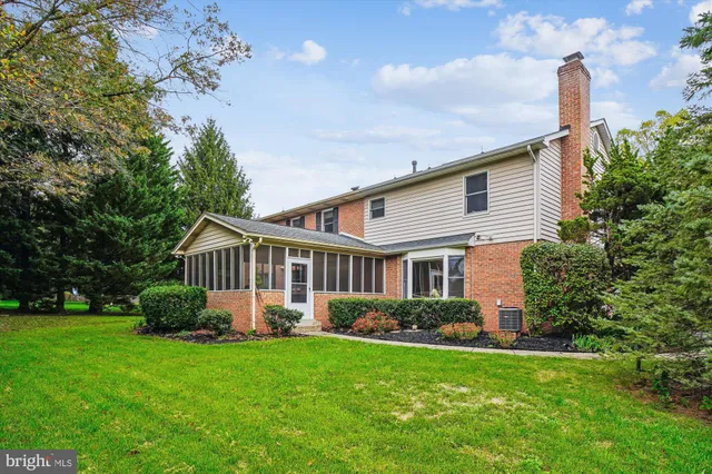 a front view of a house with a yard and trees