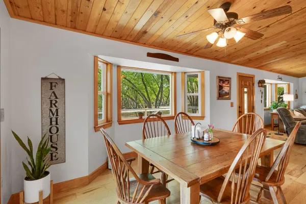 a dining room with stainless steel appliances a dining table and chairs with wooden floor