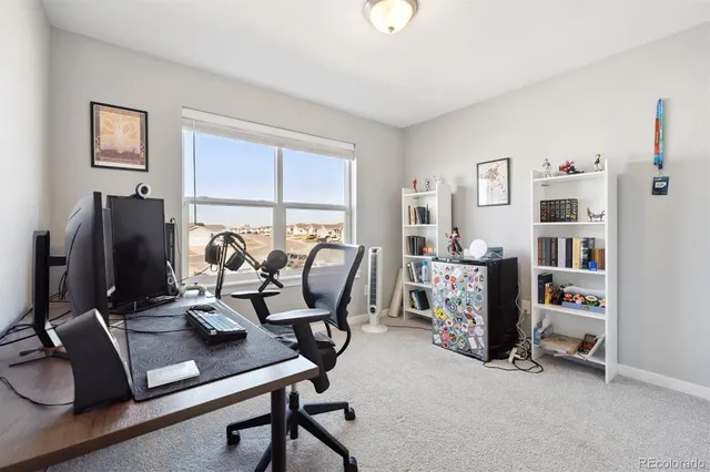 a work room with furniture a flat screen computer and a window