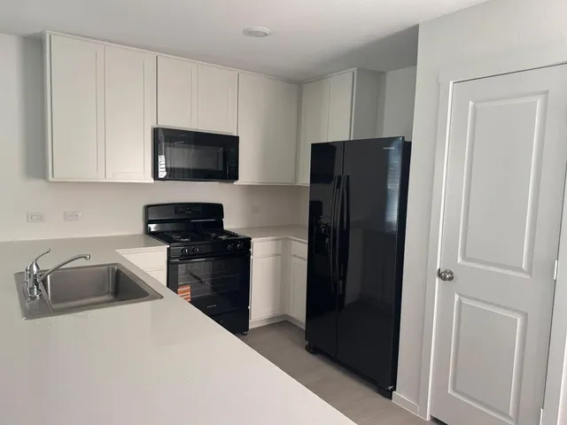 a kitchen with a refrigerator stove and cabinets