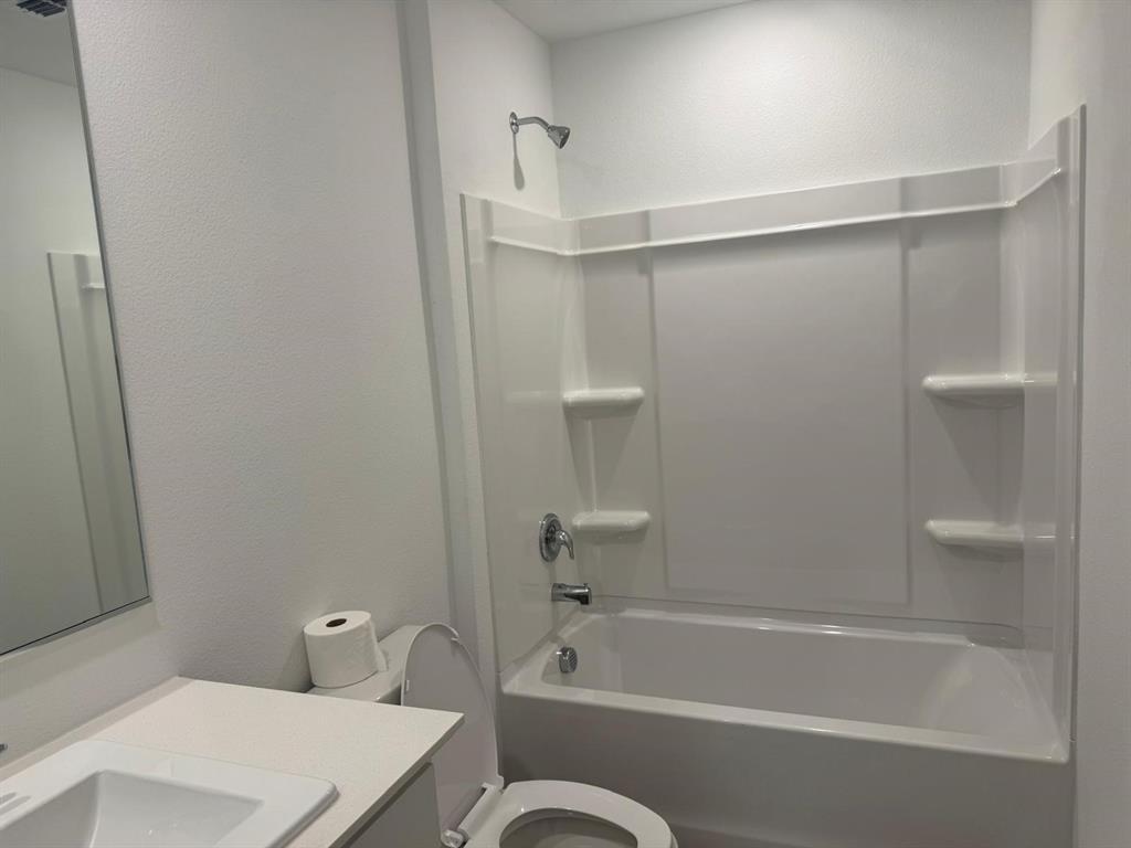 7505 Fenton Parkway Pilot Point, TX 76258 - Photo 22 of 30 a bathroom with a shower and a toilet