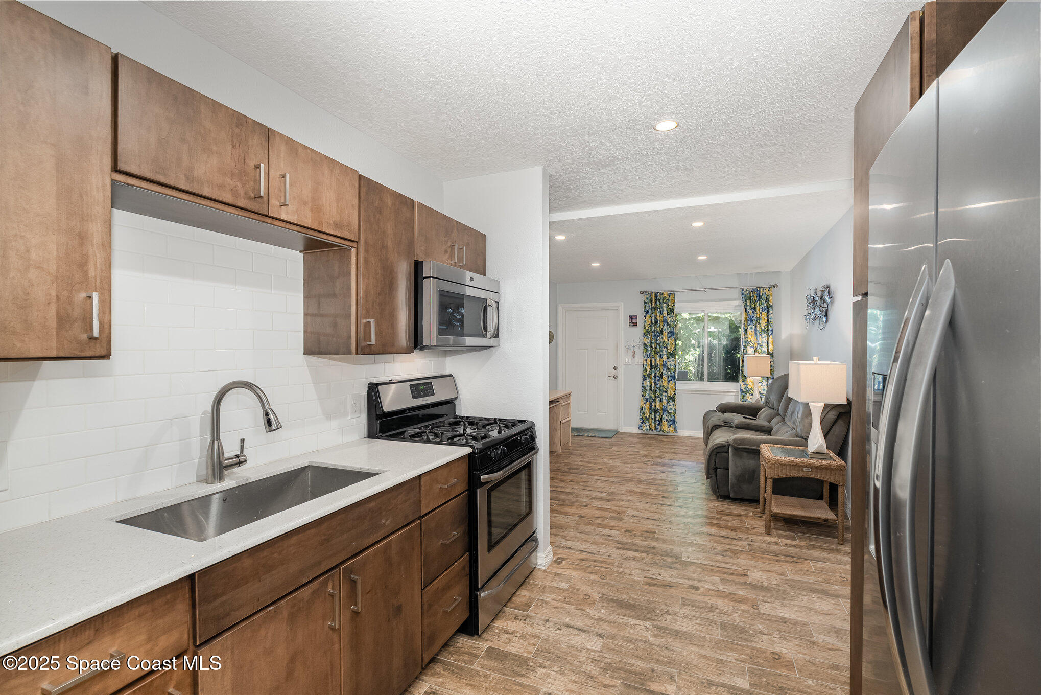 6203 Ridgewood Avenue Cocoa Beach, FL 32931 - Photo 11 of 37 a kitchen with stainless steel appliances granite countertop a sink stove and refrigerator