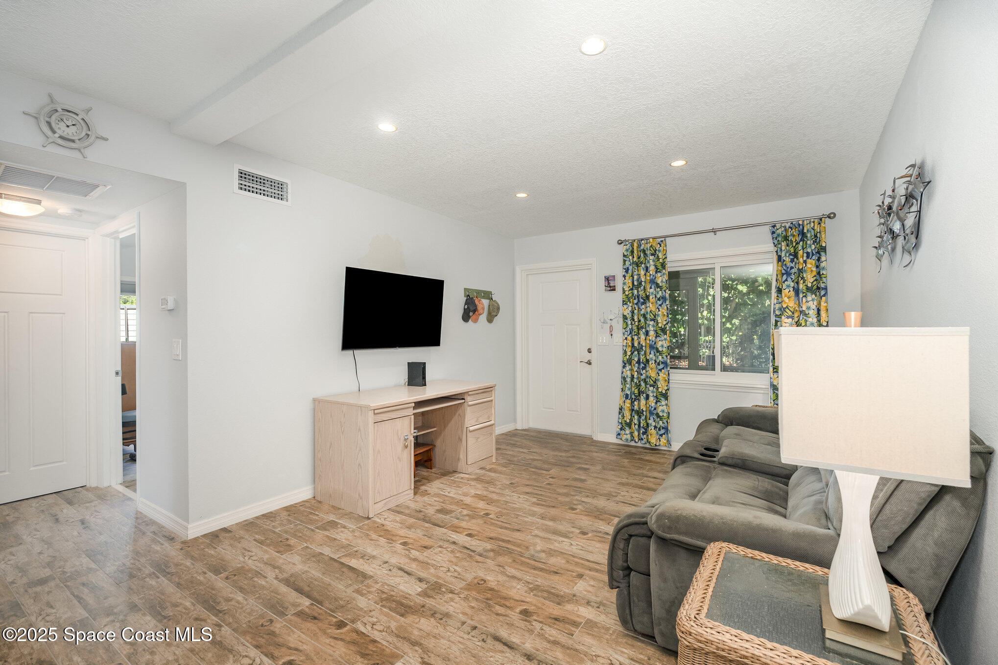 6203 Ridgewood Avenue Cocoa Beach, FL 32931 - Photo 12 of 37 a living room with furniture and a flat screen tv