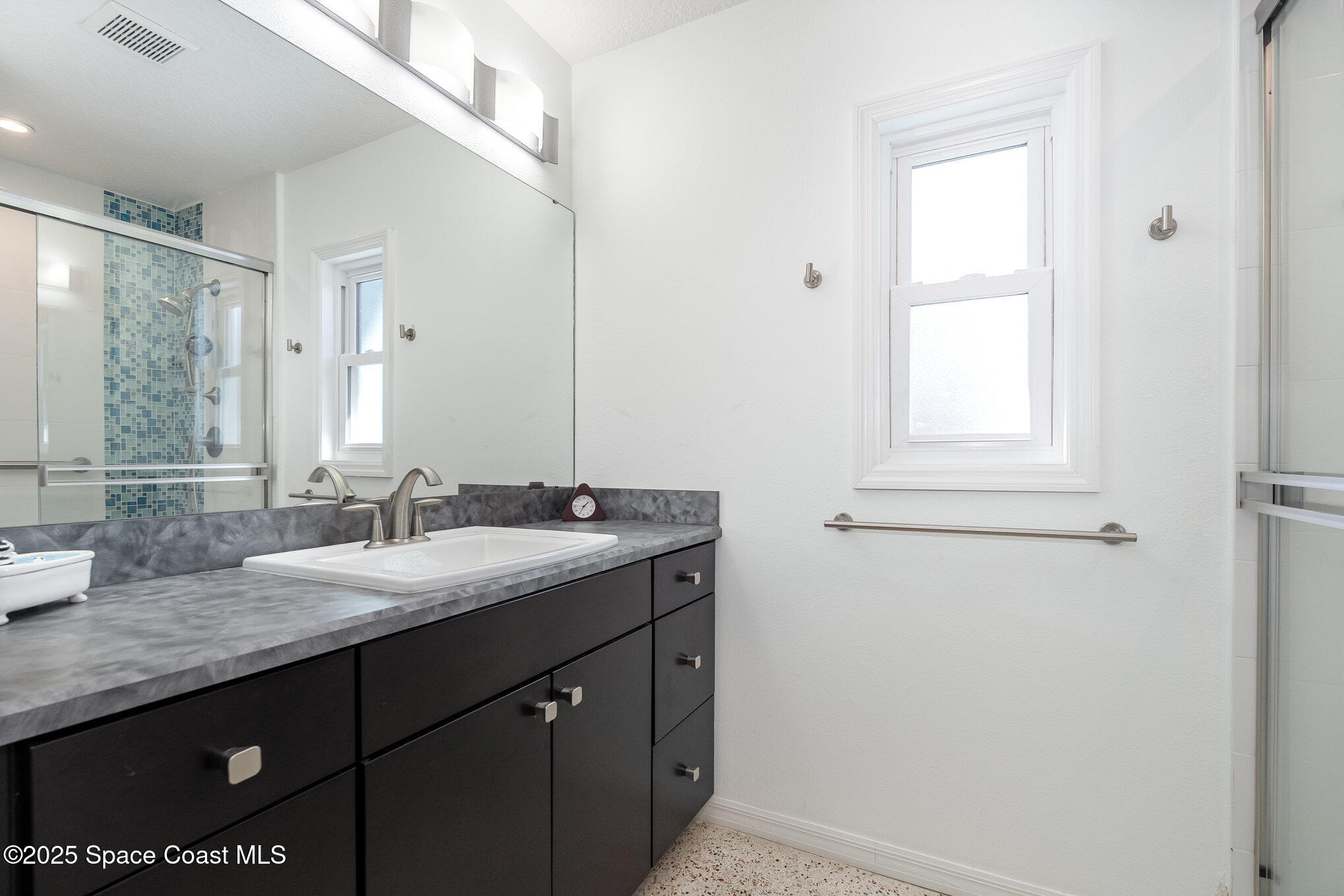 6203 Ridgewood Avenue Cocoa Beach, FL 32931 - Photo 18 of 37 a bathroom with a granite countertop sink and a mirror