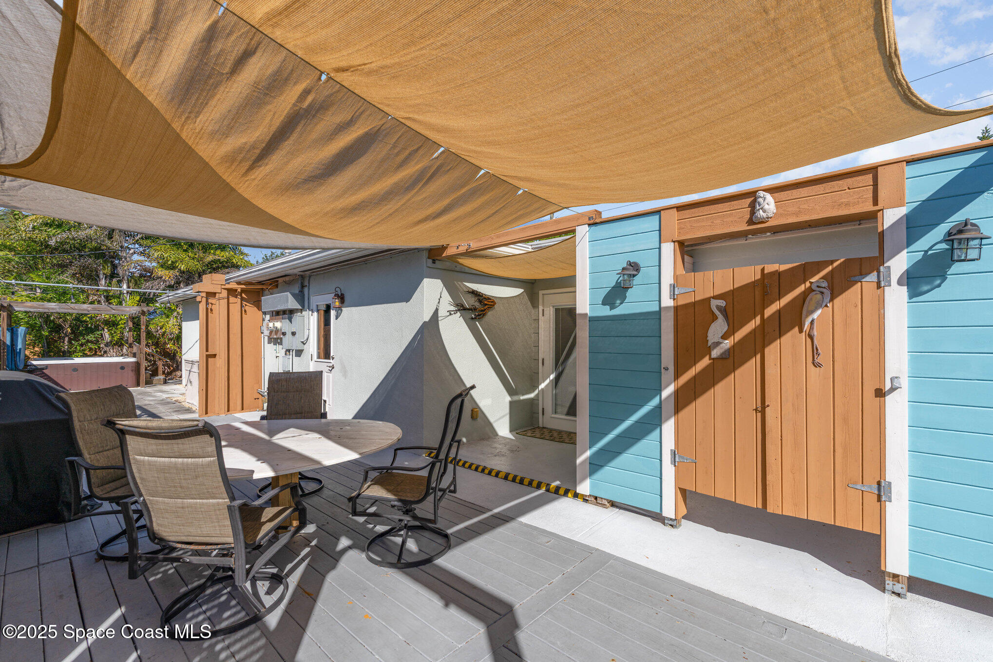 6203 Ridgewood Avenue Cocoa Beach, FL 32931 - Photo 29 of 37 a view of a patio with table and chairs with wooden floor and fence
