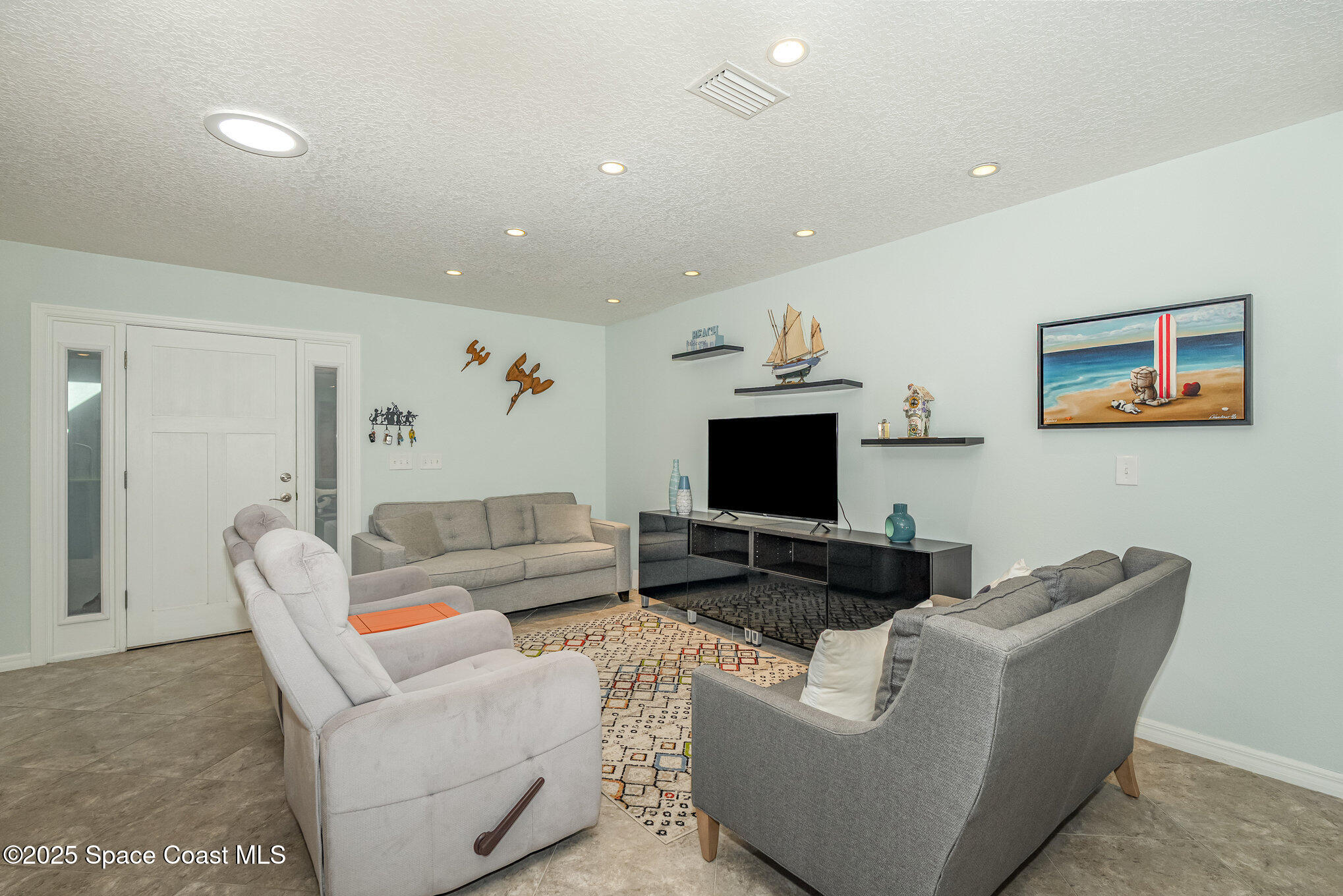 6203 Ridgewood Avenue Cocoa Beach, FL 32931 - Photo 6 of 37 a living room with furniture and a flat screen tv