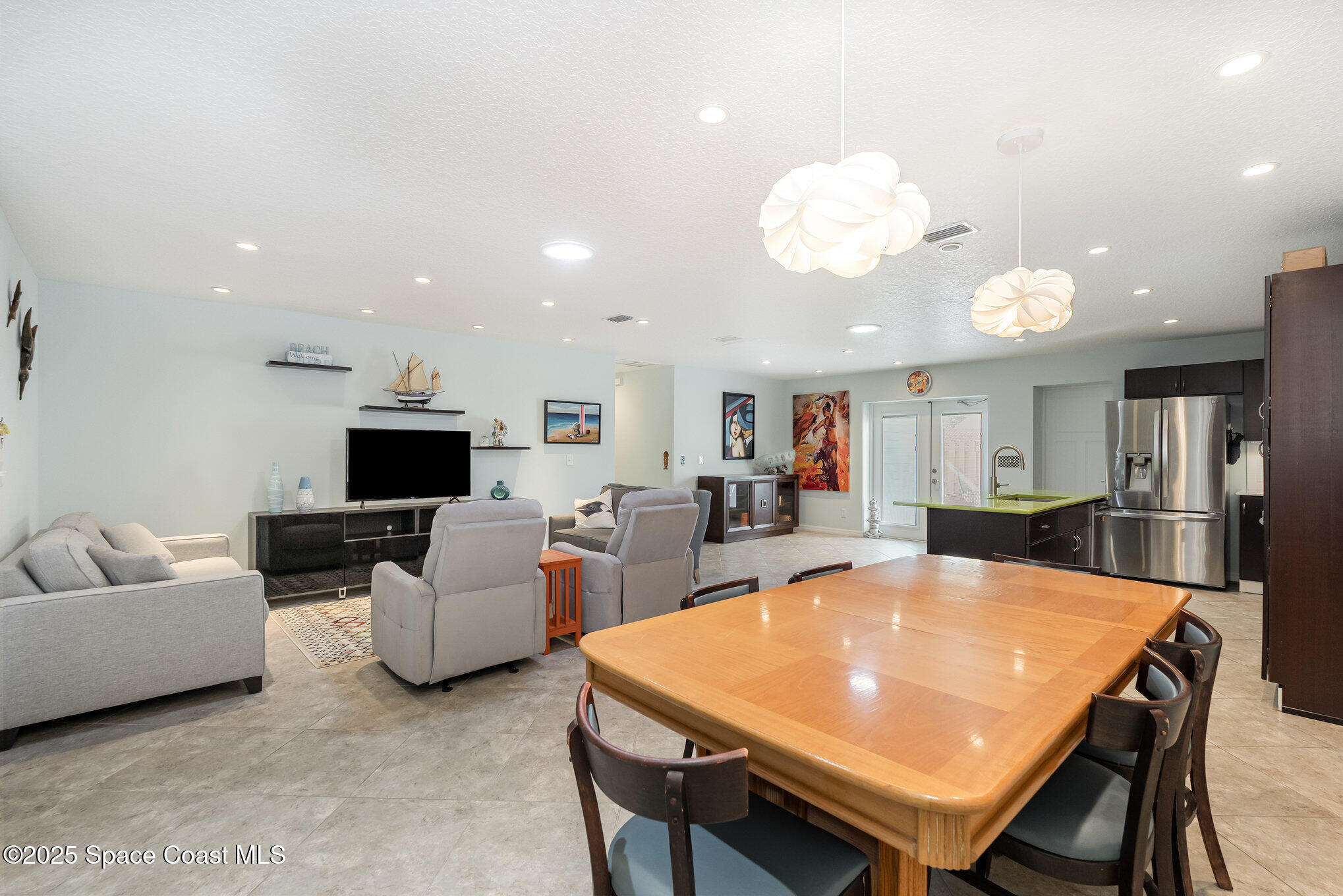 6203 Ridgewood Avenue Cocoa Beach, FL 32931 - Photo 7 of 37 a living room with furniture a flat screen tv and kitchen view