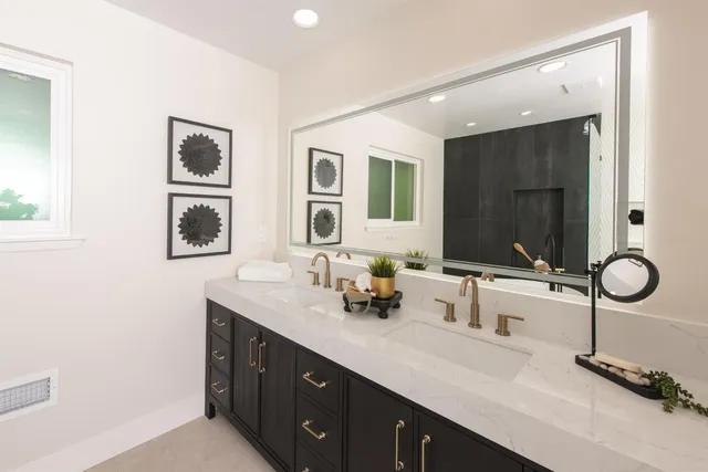 a en suite bathroom with double vanity and a mirror