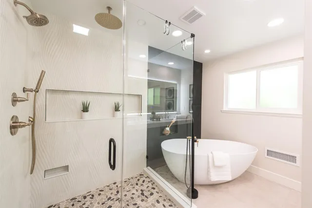 a bathroom with a granite countertop sink a mirror and shower