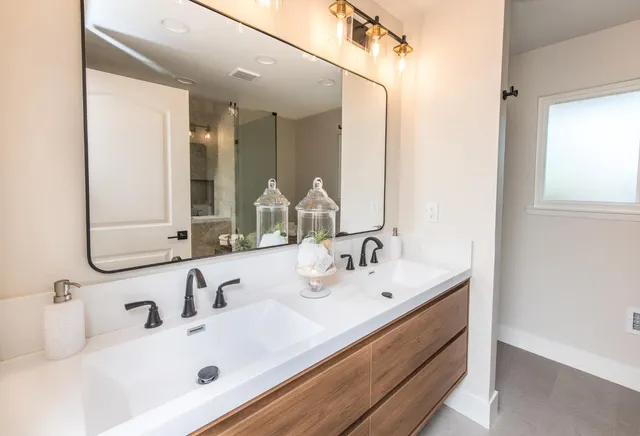 a bathroom with double vanity sinks and a mirror