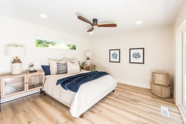 a bedroom with a bed and wooden floor