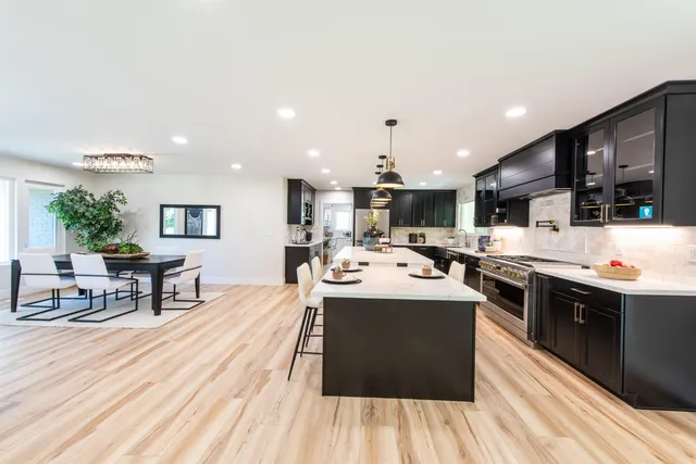 a kitchen with stainless steel appliances kitchen island granite countertop a stove and a refrigerator