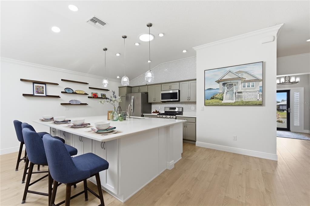 4788 Rostas Way The Villages, FL 32163 - Photo 16 of 40 a kitchen with stainless steel appliances kitchen island granite countertop a stove a sink a dining table and chairs