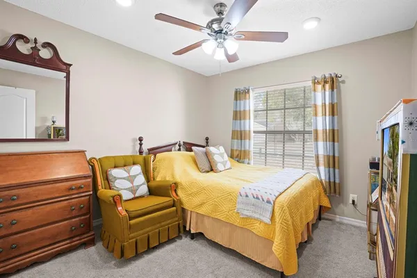 a bedroom with a bed couch and a window