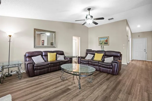 a living room with furniture and a wooden floor