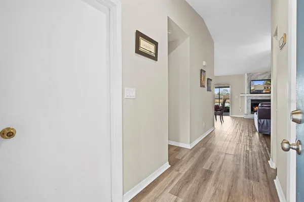 a view of a hallway with wooden floor and a living room