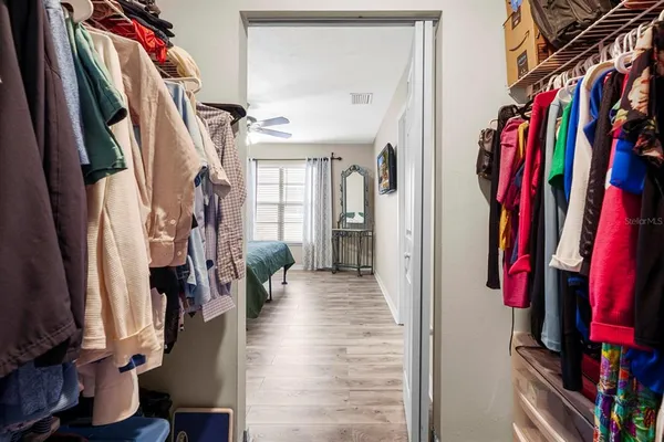 a view of walk in closet with clothes and shoes