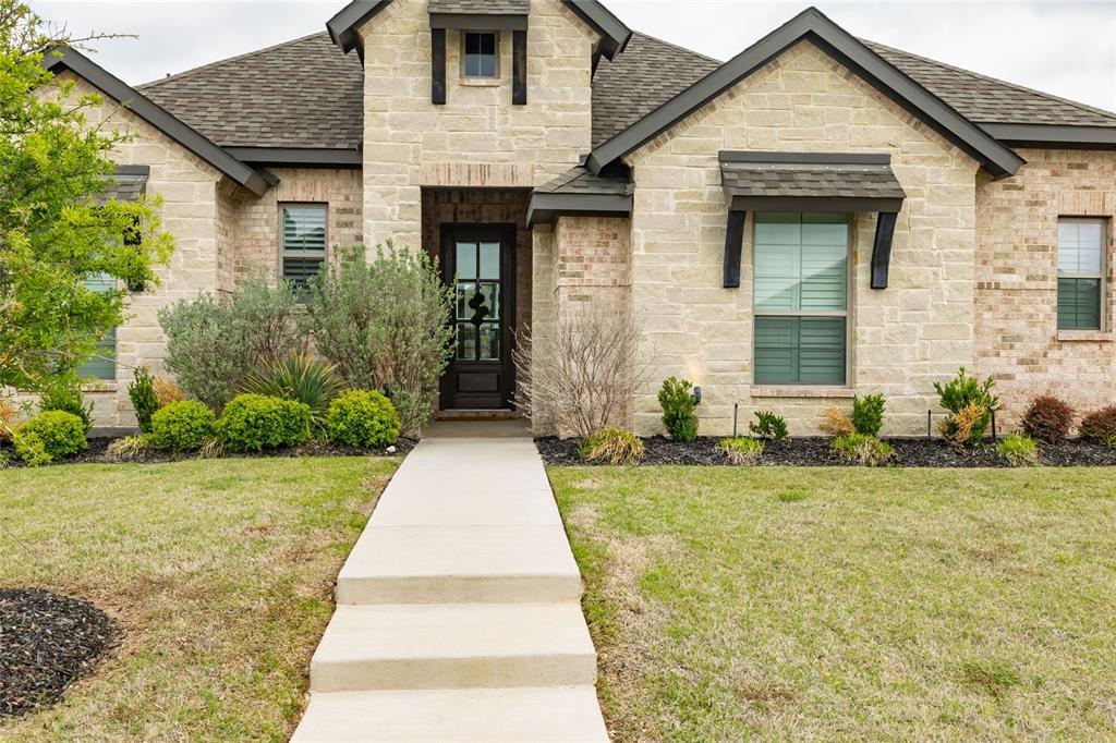 4045 Grove Valley Road Midlothian, TX 76065 - Photo 4 of 34 French provincial home with roof with shingles, stone siding, a front yard, and brick siding
