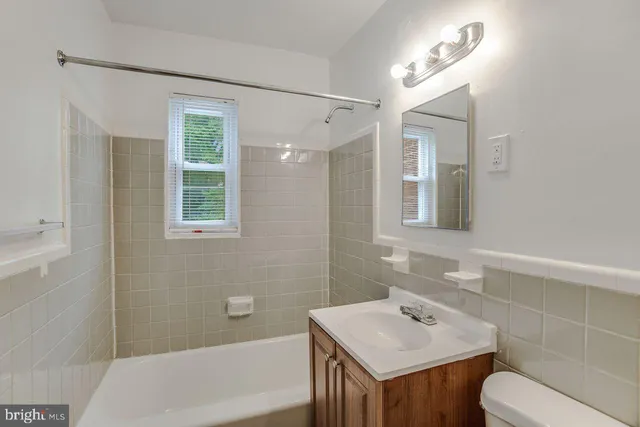 a bathroom with a sink toilet vanity and bathtub