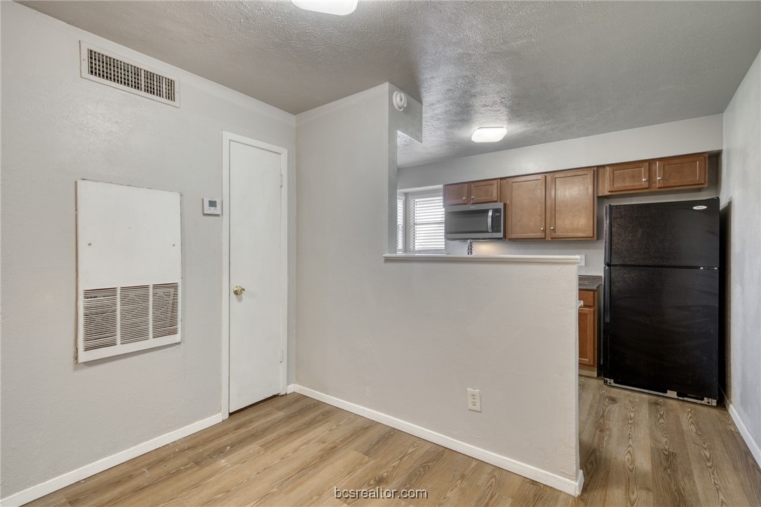 2400 Toro Lane, Unit A Bryan, TX 77807 - Photo 7 of 8 a kitchen with a refrigerator cabinet and a microwave