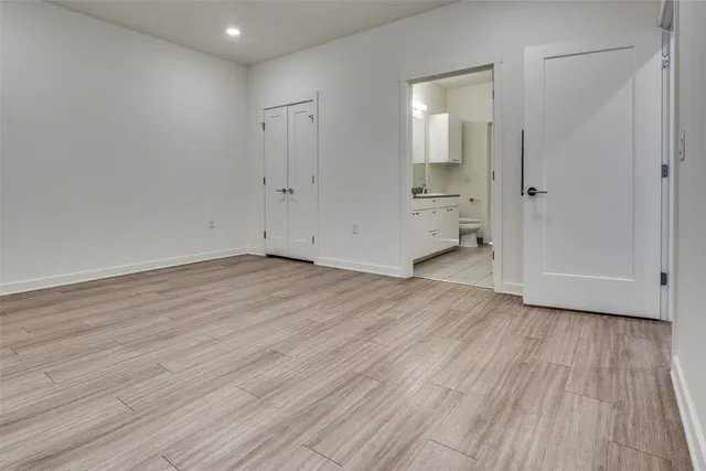 wooden floor in an empty room with a bathroom