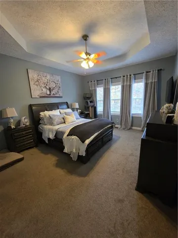 a spacious bedroom with a bed and a chandelier