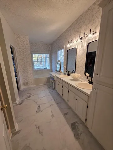a bathroom with a tub sink and mirror