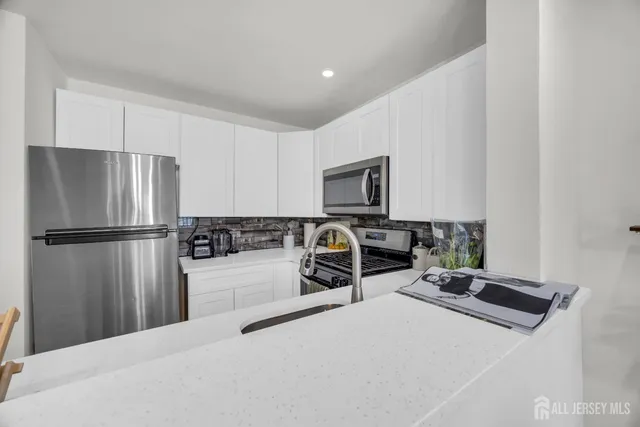 a kitchen with a refrigerator a stove and a sink
