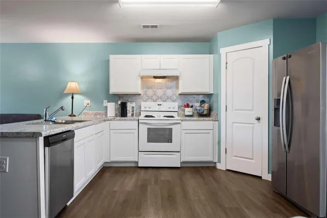 a kitchen with a stove cabinets and wooden floor