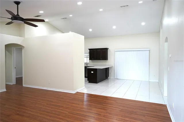 a view of a big room with wooden floor and a ceiling fan