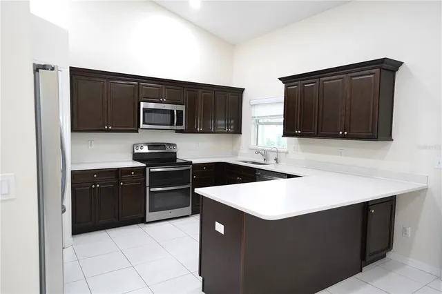 a kitchen with stainless steel appliances a stove microwave and sink
