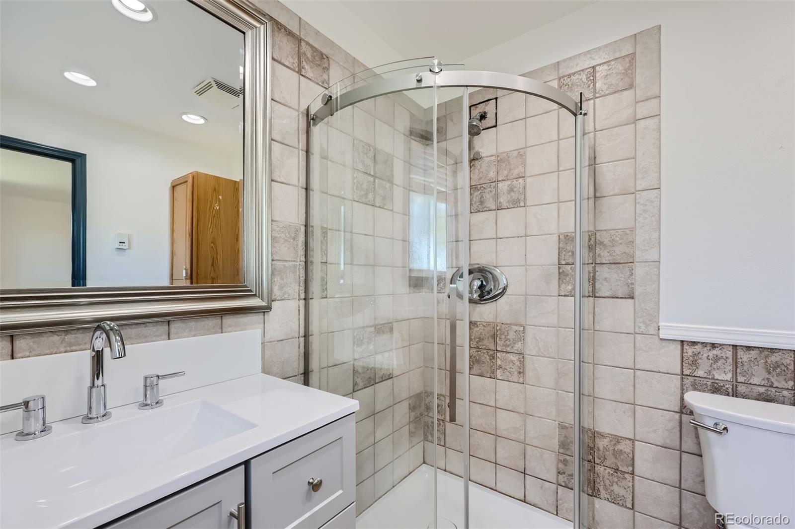 2452 Shetland Trail Elizabeth, CO 80107 - Photo 16 of 42 a bathroom with a sink mirror and shower