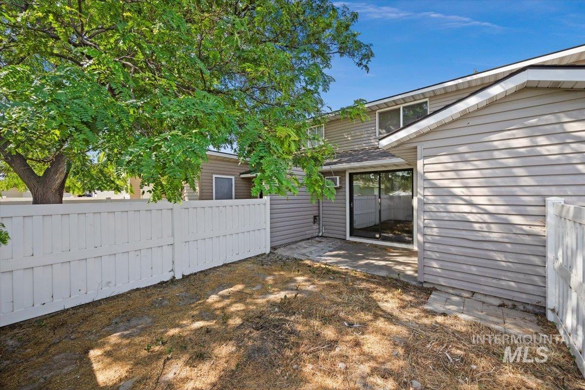 259 Pheasant Road, Unit 84 Twin Falls, ID 83301 - Photo 22 of 25 Exterior featuring horizontal vinyl siding, a white privacy fence, a concrete patio, and a mature tree