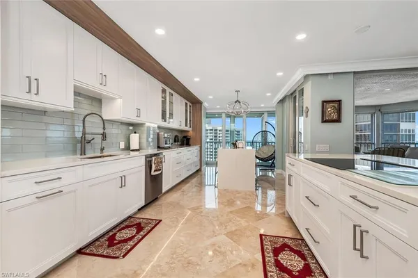 a large white kitchen with stainless steel appliances lots of counter top space