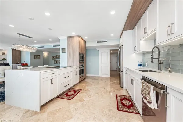 a large white kitchen with cabinets